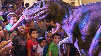 One brave youngster gets up close and personal with a dinosaur, not quite sure if it will bite. Children, young and not so young, enjoyed celebrating Eid with dinosaurs at an event in the World Trade Centre, Abu Dhabi on Thursday. Delores Johnson / The National