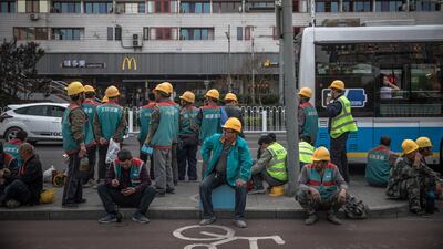 Chinese workers wait for a public bus in Beijing. China's economy grew 6.4 per cent in the first quarter compared to the same period last year. EPA/ROMAN PILIPEY