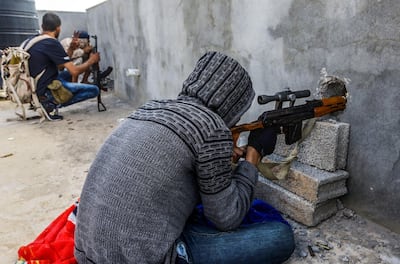 A fighter looks through the scope of a rifle mounted through a murder hole at a position held by forces loyal to Libya's Government of National Accord (GNA). AFP