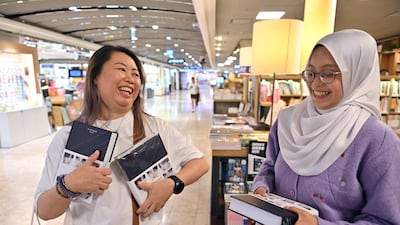 BTS fans Audrey, left, and Aqilah, who visited Seoul from Malaysia to purchase copies of the book on the day of its release