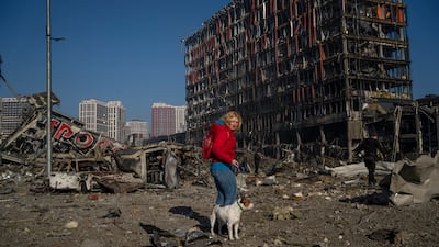 Irina Zubchenko walks her dog Max amid the destruction caused by the shelling of a shopping center in Kyiv. AP