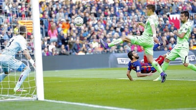 FC Barcelona's Arda Turan, center back, kicks the ball to score past Getafe's goalkeeper Vicente Guaita, left, during a Spanish La Liga soccer match at the Camp Nou stadium in Barcelona, Spain, Saturday, March 12, 2016. (AP Photo/Manu Fernandez)