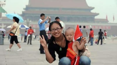 A mother holding her child poses for a photo at the Tiananmen Square. Chinese tourist officials have reassured visitors the country is safe after an attack in the western region.