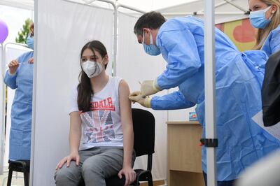 A girl receives her injection of Pfizer's Covid-19 vaccine in Bucharest, Romania. The UK has approved use of the shot in those aged 12 to 15. AP