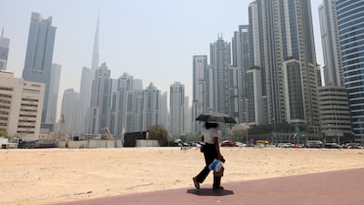 A resident takes shade on a hot May day. Business Bay, Dubai. Chris Whiteoak / The National