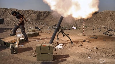 An Iraqi militia fighter from Shiite cleric Moqtada Al Sadr's Saraya Al Salam, fires a mortar during heavy clashes with Islamic State in Iraq and the Levant fighters in Tuz Khurmatu in Salaheddin province about 88 kilometres south of Kirkuk on August 31. Iraqi forces broke through to the ISIL-besieged Shiite town of Amerli, where thousands of people have been trapped for more than two months with dwindling food and water supplies. AFP Photo