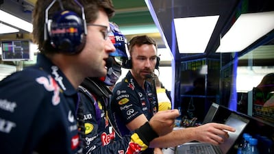 Carlos Sainz Jr. of Spain and Infiniti Red Bull Racing speaks with race engineer Simon Rennie in the garage during day one of Formula One testing at Yas Marina Circuit on November 25, 2014 in Abu Dhabi, United Arab Emirates. (Photo by Dan Istitene/Getty Images)