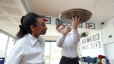 Luca Trudgeon and fellow student Lamees Saad Omer get to work at Dubai Offshore Sailing Club. Chris Whiteoak / The National