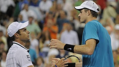 Andy Roddick, left, lost to John Isner, a player he has mentored in the past. Timothy Clary / AFP