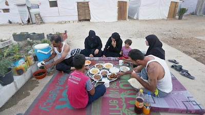 Syrian refugees share a meal in Marj, Lebanon on June 29. Bilal Hussein / AP Photo