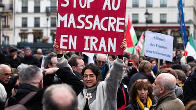A protester holds a placard reading ''Stop the massacres in Iran'' during an anti-government rally in support of the Iranian people in Paris. Getty Images