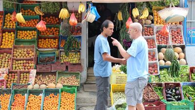 Men chat outside a fruit shop after Tunisia relaxed its lockdown due to the coronavirus disease outbreak, in La Marsa, near Tunis, Tunisia. Reuters