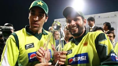 Pakistani cricketers Umer Gul, left, and Shahid Afridi hold the Fortune Cup as they celebrate winning against the West Indies in Abu Dhabi.