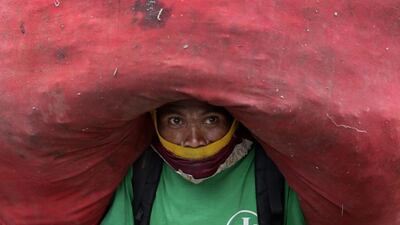 A Filipino scavenger carries a sack loaded with recyclable materials before a feast of ‘pagpag’ (recycled food) at the Payatas dump site ahead of Pope Francis’ visit in Quezon City, eastern Manila, Philippine. Dennis M. Sabangan / EPA