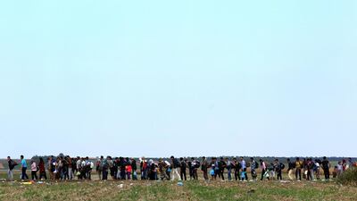 Migrants and asylum seekers walk through a field near the western Serbian town of Sid, toward the border between Serbia and Croatia. Once inside the EU, there is nothing to stop people from moving to other countries in the union. AFP