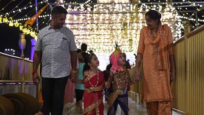 Children dressed as Krishna and Goddess Radha walk along with their parents. AFP