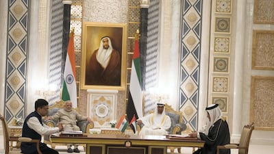 HH Sheikh Mohamed bin Zayed Al Nahyan Crown Prince of Abu Dhabi Deputy Supreme Commander of the UAE Armed Forces (back R) and HE Narendra Modi, Prime Minister of India (back L), witness an MOU signing between Bombay Stock Exchange and Abu Dhabi Securities Exchange. Seen signing are HE Rashid Al Baloushi, Chief Executive of Abu Dhabi Securities Exchange, and Ashish Kumar Chauhan, Managing Director and Chief Executive Officer of Bombay Stock Exchange. Photo: Mohamed Al Hammadi / Crown Prince Court - Abu Dhabi