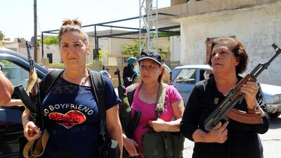 Women pose with guns in front of journalists in the Christian village of Qaa, where suicide bomb attacks took place on Monday, in the Bekaa valley, Lebanon. Hassan Abdallah / Reuters