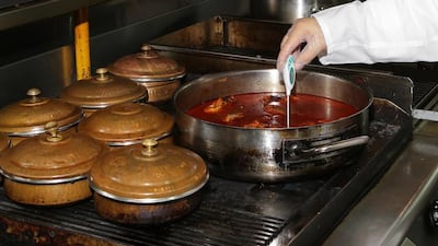 A Dubai Municipality food inspector checks dishes being cooked at a restaurant. Courtesy Dubai Municipality