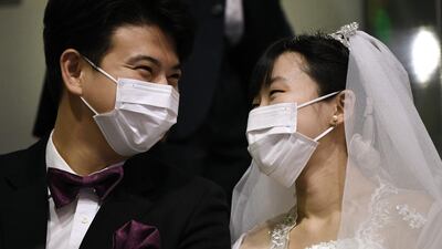 A couple wearing protective face masks attend a mass wedding ceremony organised by the Unification Church at Cheongshim Peace World Center in Gapyeong. AFP