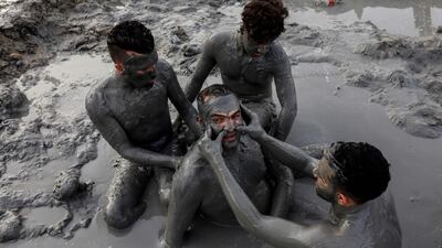 Palestinians cover themselves with Dead Sea mud. Menahem Kahana / AFP