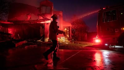 A firefighter assesses the damage of a home from the Tick Fire in Santa Clarita, California. AP Photo