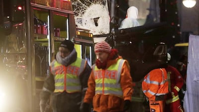 A criminal expert looks into the cabin of a lorry which ran into a crowded Christmas market Monday evening, killing 12 people in Berlin. Markus Schreiber / AP
