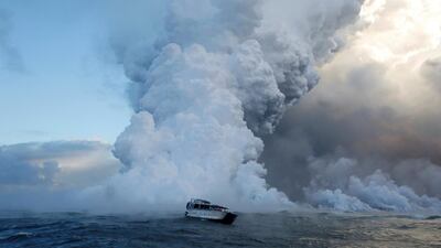 People watch from a tour boat as lava flows into the Pacific Ocean in the Kapoho area, east of Pahoa. Terray Sylvester / Reuters
