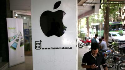A man checks his smartphone while passing an unlicenced Apple store in Isfahan, Iran. John Moore / Getty Images