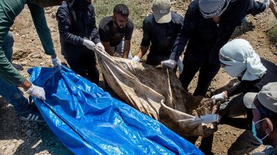 Members of the Civil Defence Unit retrieve bodies from a mass grave in Zoo park in Raqqa's Al Furat neighborhood. Arianna Pagani for The National