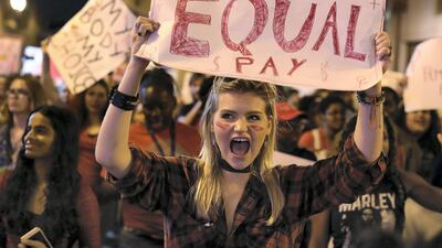 MIAMI, FL - MARCH 08: Clarissa Horsfall holds a sign reading, 'Equal Pay,' as she joins with others during 'A Day Without A Woman' demonstration on March 8, 2017 in Miami, United States. The demonstrators were calling for woman to have equity, justice and human rights for women and all gender-oppressed people. (Photo by Joe Raedle/Getty Images)