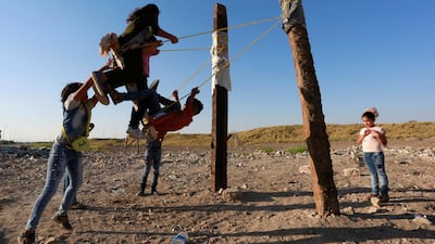 Iraqi children ride on a swing at an amusement park in Babel province south of Baghdad, Iraq. Alaa al-Marjani / Reuters