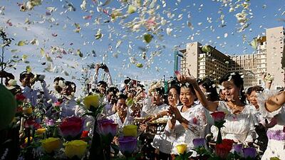 epa03011295 Cambodian officials throw flowers on a stupa to commemorate victims of the 2010 bridge stampede, during a ceremony in Phnom Penh, Cambodia, 22 November 2011. Phnom Penh municipality is inaugurating a stupa in honor of the victims who died on the Diamond Island bridge when a stampede took place in November 2010. At least 353 people died and 395 were injured after they panicked while crossing the bridge during Water Festival celebrations. EPA/MAK REMISSA