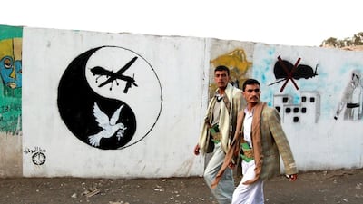 Men walk by a mural of a US drone and a dove in a yin-yang symbol in Sanaa, Yemen. In The Angel of History by Rabih Alameddine we learn about the adventures of a drone that crash lands in Yemen. Mohammed Huwais / AFP