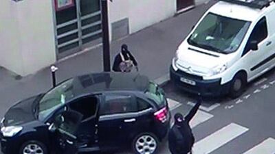 Gunmen gesture on January 7, 2015, as they return to their car outside the offices of French satirical weekly newspaper Charlie Hebdo after the attack. Reuters