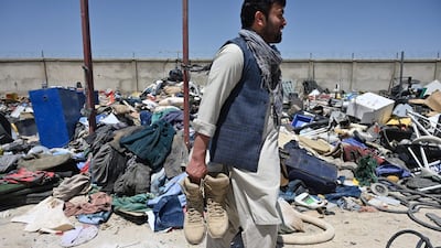 A man holds shoes as he selects valuable items at a recycling workshop near the Bagram Air Base. AFP