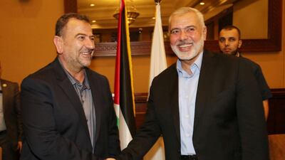 Hamas chief Ismail Haniyeh shakes hands with his deputy Saleh Al Arouri in Gaza City. Hamas Chief Media Office via REUTERS