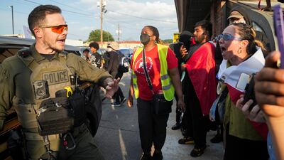 A police officer controls the demonstrators during a protest against federal immigration sweeps, in Atlanta, Georgia. Reuters