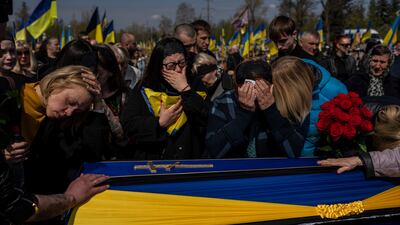 Relatives mourn next to the coffin of Ukrainian serviceman Andrii Vorobiov at the Kryvyi Rih cemetery in eastern Ukraine on Monday. AP Photo