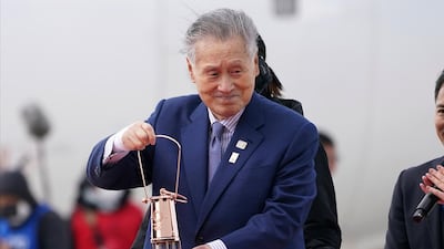 Yoshiro Mori holds the Olympic flame after its arrival at the Matsushima airbase in Miyagi prefecture on March 20, 2020. AP Photo