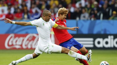 South Korea's Son Heung-min, right, prepares to score his side's first goal as Algeria's Madjid Bougherra defends during the Group H World Cup match at the Estadio Beira-Rio in Porto Alegre, Brazil, on June 22, 2014. Jon Super / AP Photo