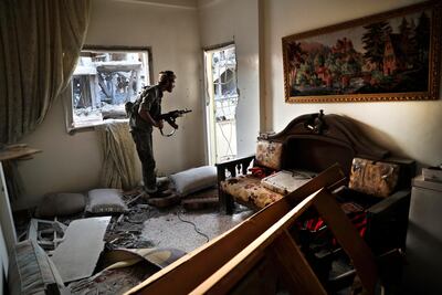A Syrian Democratic Forces fighter looks through a window inside a destroyed apartment on the front line against ISIS in Raqqa. AP