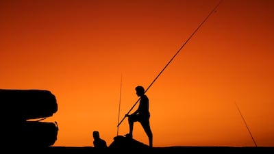 Palestinians are silhouetted as they fish during sunset in the west Gaza City, 17 September 2017. EPA