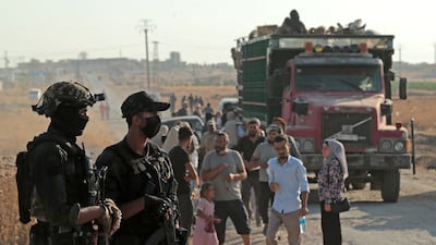 Security personnel stand guard as Syrian Kurds prepare to head back to the north-eastern border town of Ras Al Ain after years of displacement. AFP