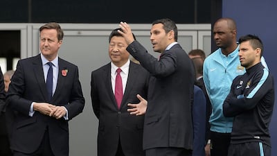 Britain's prime minister David Cameron, left, stands with China's president Xi Jinping, centre, and Manchester City chairman Khaldoon Al Mubarak, third right, during a visit to the City Football Academy in Manchester in October. Joe Giddens / Reuters