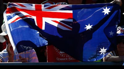 A fan holds an Australian flag during the men's singles match between Mikhail Youzhny and Matthew Ebden at the Australian Open. Daniel Munoz / Reuters