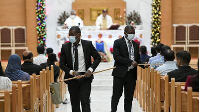 Donations are given during Christmas Eve midnight mass at St Paul's Catholic Church in Mussafah, Abu Dhabi. Khushnum Bhandari for The National