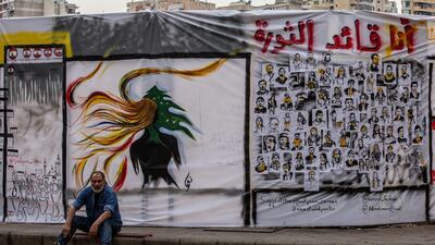 A protester sits next a graffiti with Arabic words reading 'I am the leader of revolution' at Riad El-Solh square in downtown Beirut. EPA