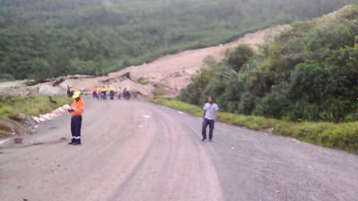 Locals inspect a landslide and damage to a road located near the township of Tabubil after an earthquake that struck Papua New Guinea's Southern Highlands, on February 26, 2018. Jerome Kay / Handout via Reuters