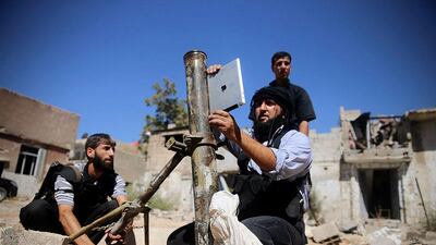 A member of the 'Ansar Dimachk' Brigade, part of the 'Asood Allah' Brigade which operates under the Free Syrian Army, uses an iPad during preparations to fire a homemade mortar at one of the battlefronts in Jobar, Damascus, Syria. Mohamed Abdullah / Reuters